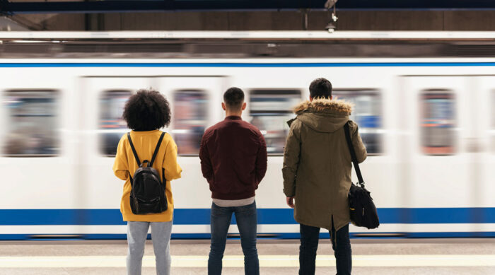 ungdomar på perrong ser tåg anlända
