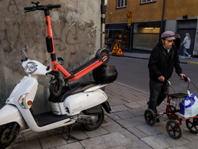 Felparkerad elscooter äldre man med rullator