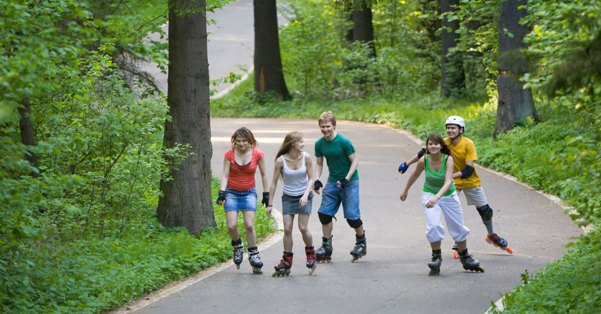 En grupp ungdomar som åker inlines i en park. Ett exempel på aktiv mobilitet.