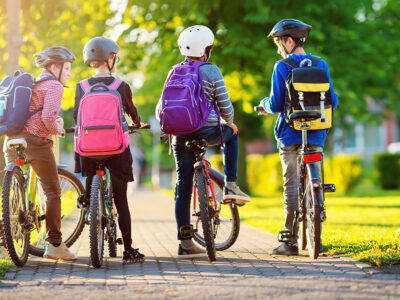 barn med ryggsäck som cyklar till skolan