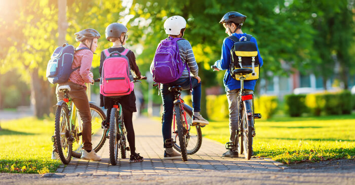 barn med ryggsäck som cyklar till skolan