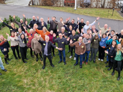 folksamling där alla stäcker upp händerna